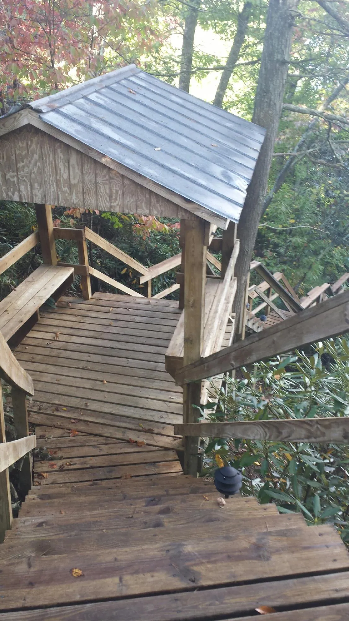 Metal roofed shelter over wooden steps on a wooded walkway — Skylight Repair & Installation work by our crew in Newfield